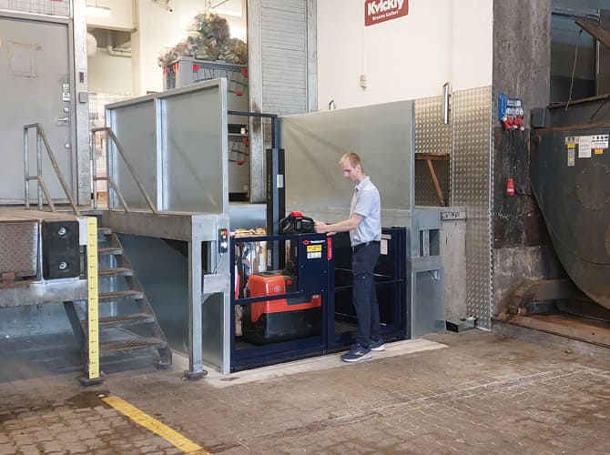 Worker opening goods lift to access goods